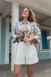 a lady wears a printed silk shirt with a white shorts